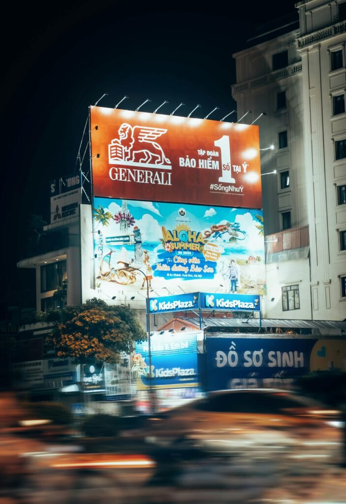 Blurred motion captures a bustling urban street at night with bright billboards.